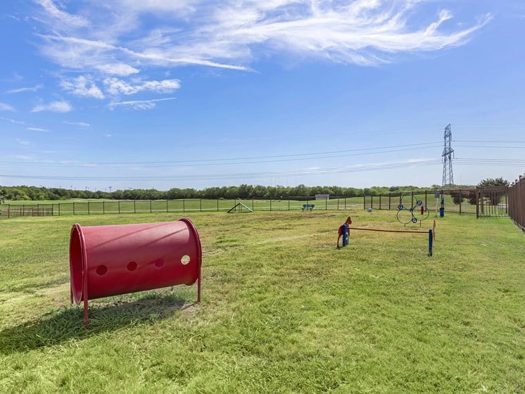 a playground in a field with a red fire hydrant